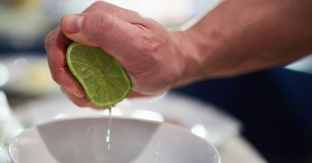Person squeezing a lime in their right hand