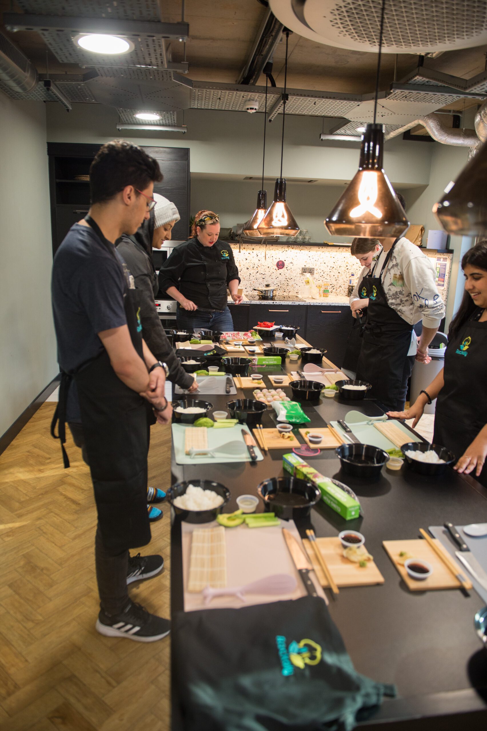 Employees participating in a Boston corporate cooking team-building event