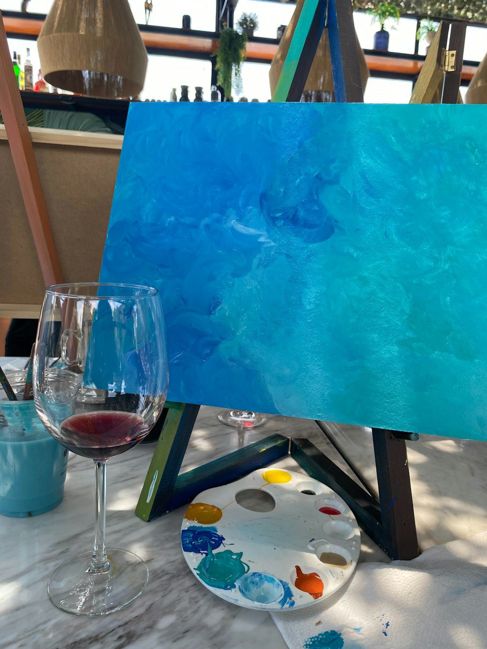 Blue canvas painting with a glass of red wine