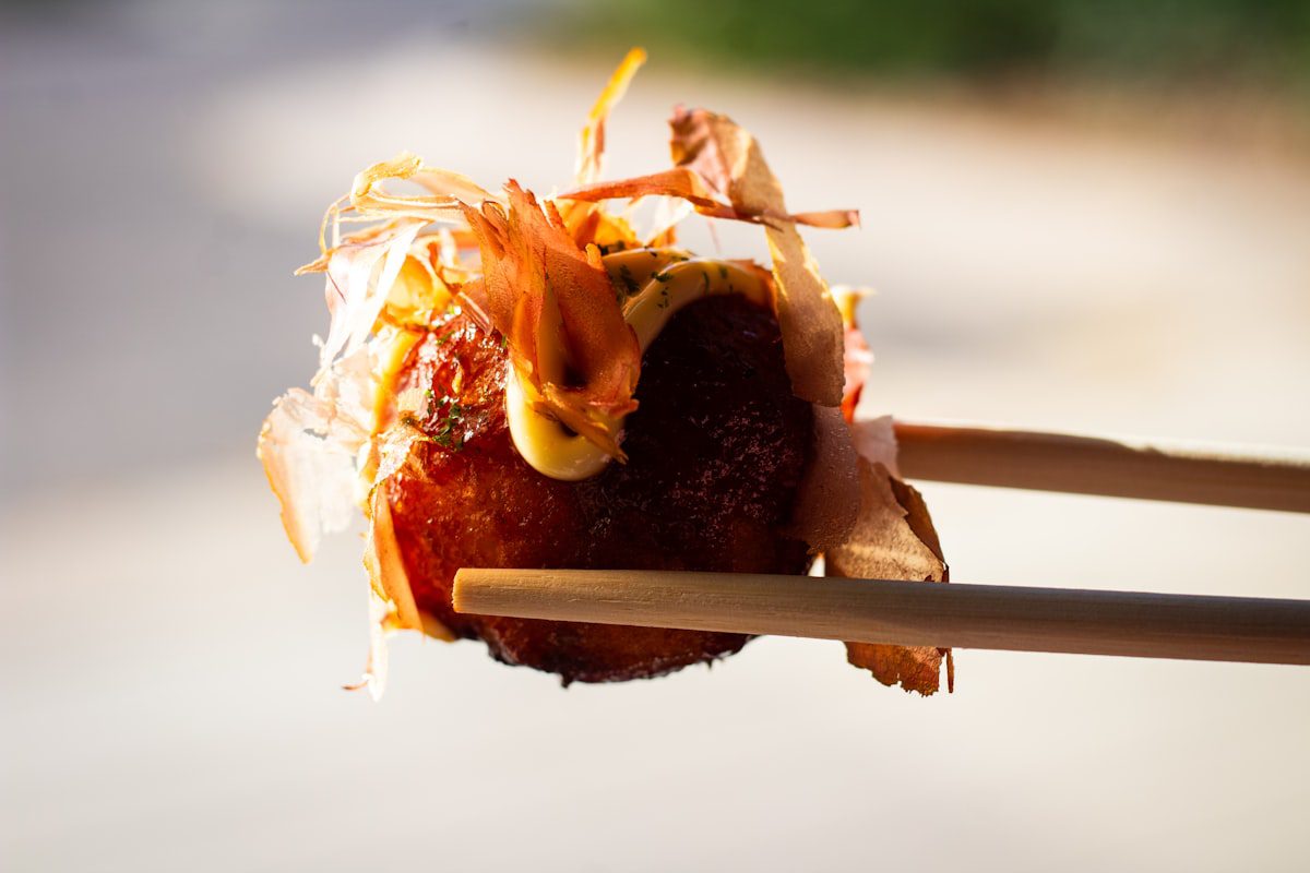 Japanese takoyaki octopus balls held with chopsticks